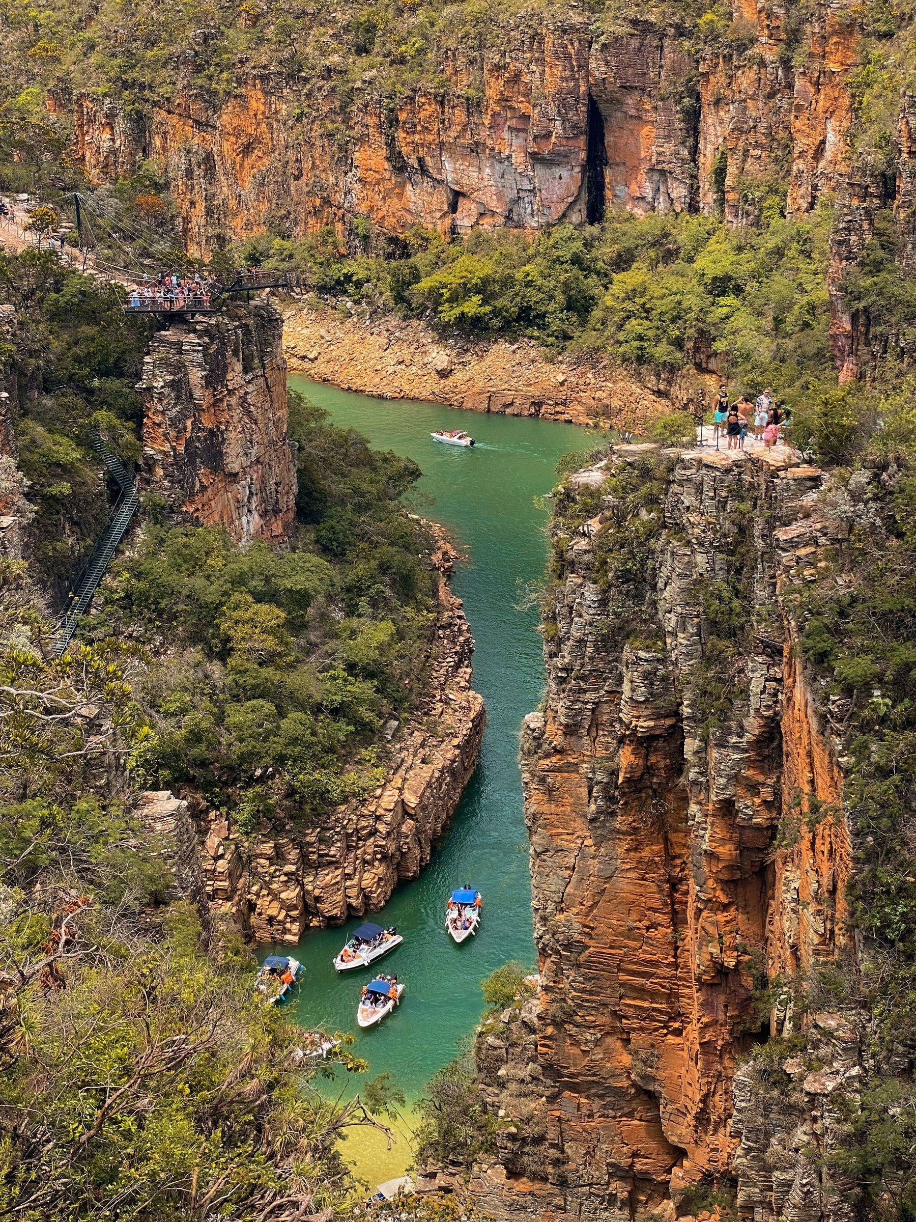 Boats exploring the water between tall canyon walls